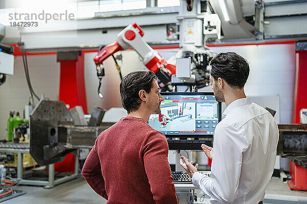 Ingenieure diskutieren miteinander in der Roboterfabrik
