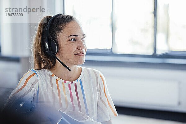 Lächelnde Geschäftsfrau mit Headset im Büro