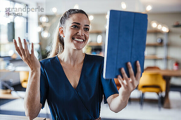 Glückliche Geschäftsfrau  die per Videoanruf über einen Tablet-PC spricht