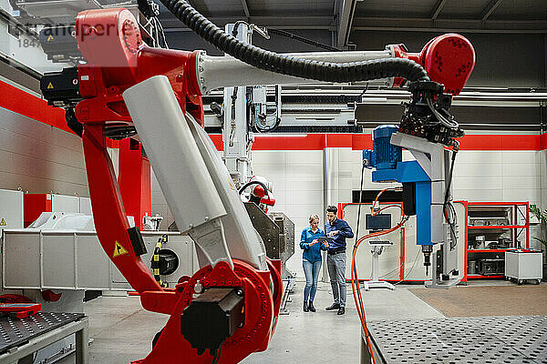 Kollegen arbeiten in der Roboterfabrik zusammen