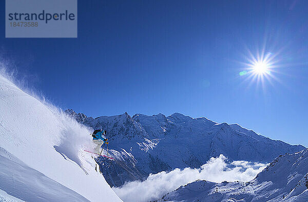 Skifahrer springt auf verschneiten Hang