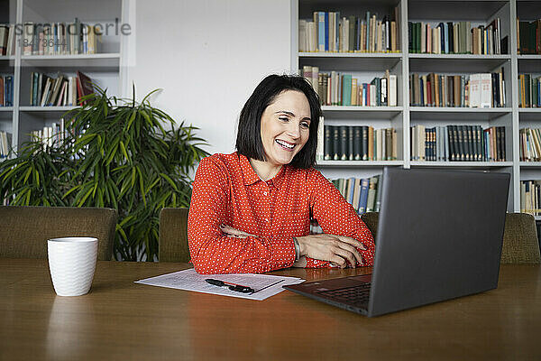 Glückliche Geschäftsfrau  die per Videoanruf über ihren Laptop spricht