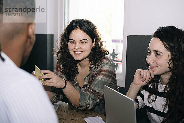 Lächelnde Geschäftsfrauen mit Kollegen im Büro