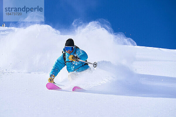 Reifer Mann fährt auf schneebedecktem Berg Ski