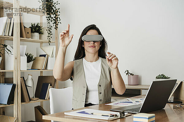 Geschäftsfrau mit Virtual-Reality-Simulator gestikuliert im Büro