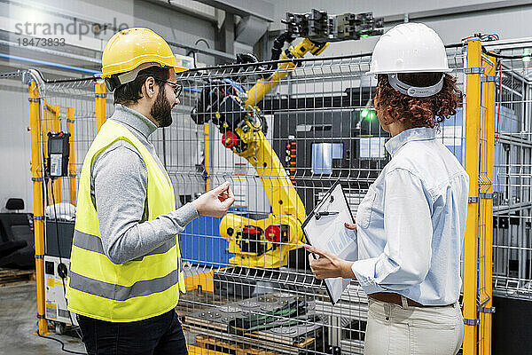 Ingenieure untersuchen Roboterarm in der Fabrik