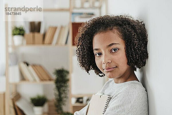 Elementary girl with curly hair at home