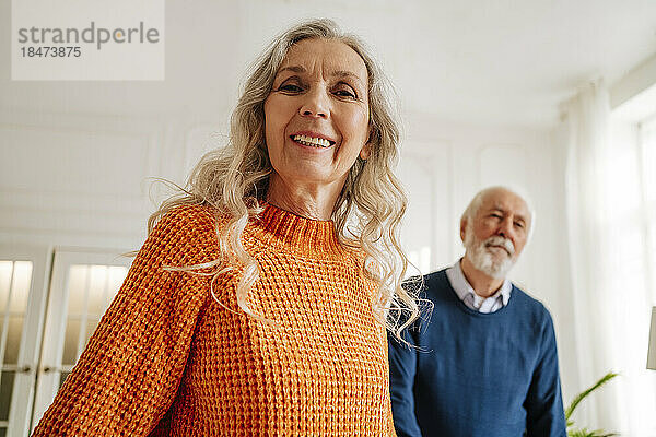 Glückliche ältere Frau mit Mann im Hintergrund
