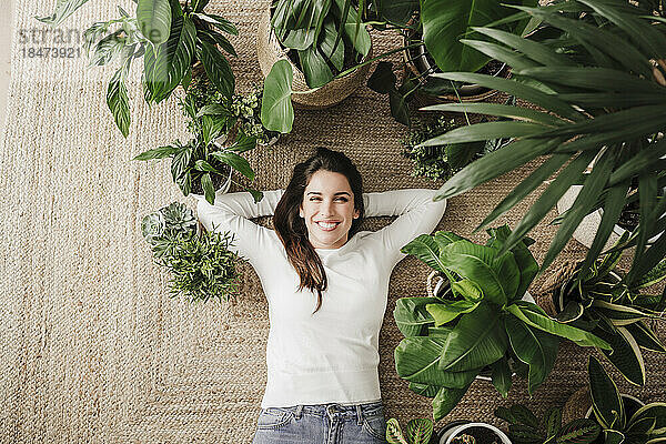 Happy woman lying down amidst plants