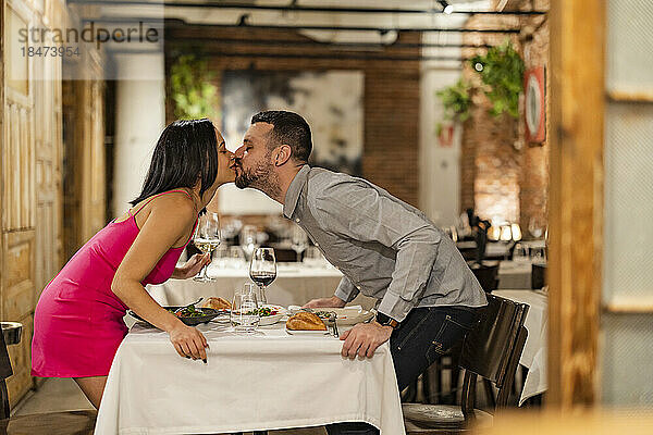 Romantic couple kissing at restaurant