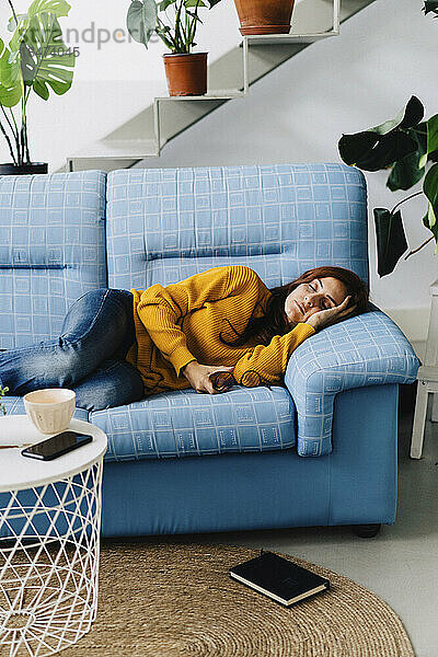 Frau entspannt sich zu Hause auf dem Sofa