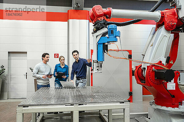 Kollegen untersuchen Roboter in der Fabrik