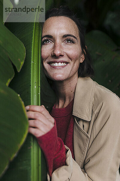Happy woman embracing green banana leaf