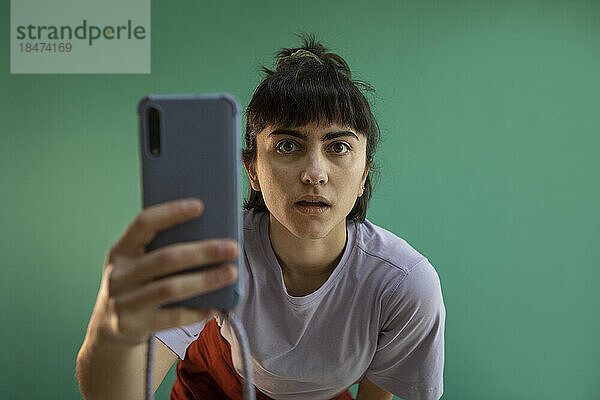 Junge Frau fotografiert mit Smartphone