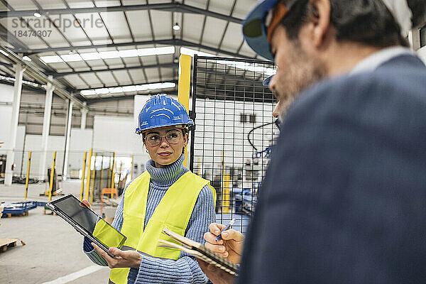 Ingenieur zeigt Kollegen über Tablet-PC in der Fabrik