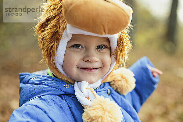 Lächelnder süßer Junge mit Löwenhut