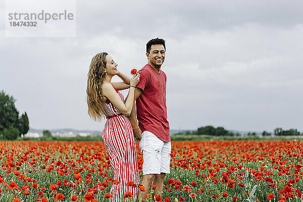 Happy young couple enjoying at poppy field