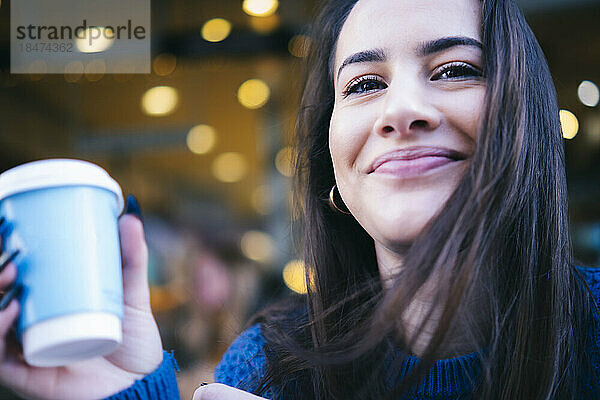 Lächelnde junge Frau mit Kaffeetasse