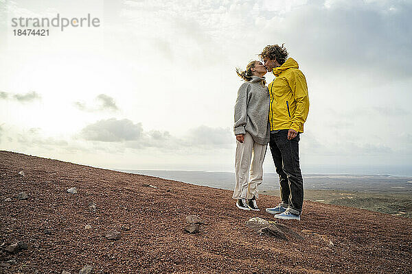 Zärtliches junges Paar  das sich auf dem Berg küsst