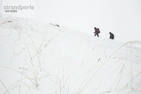 Paar wandert im Urlaub auf schneebedecktem Berg