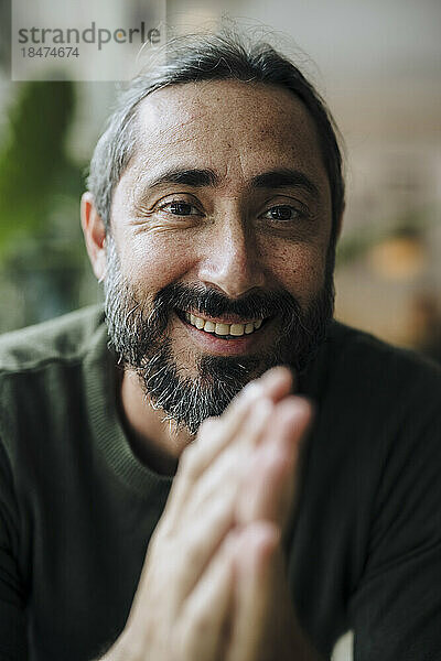 Smiling mature man with beard in cafe
