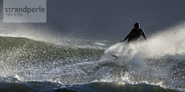 Surfer surft im Urlaub im Meer