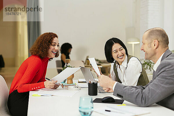 Glückliche Geschäftskollegen diskutieren im Büro