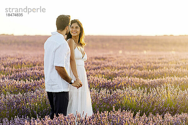 Happy couple standing in lavender field