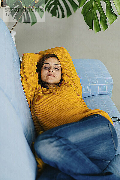 Frau entspannt sich auf dem Sofa im Wohnzimmer