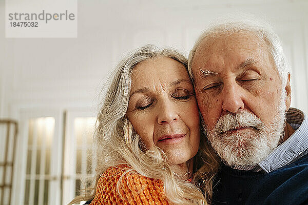 Senior man and woman embracing each other at home