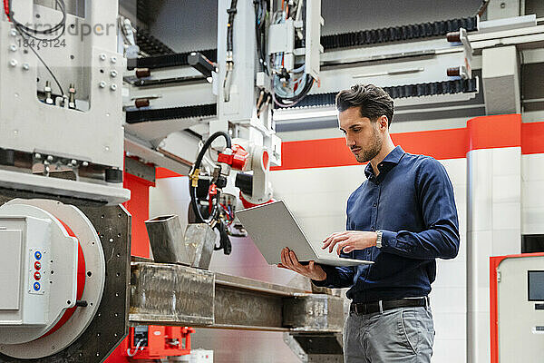 Ingenieur arbeitet am Laptop in der Roboterfabrik