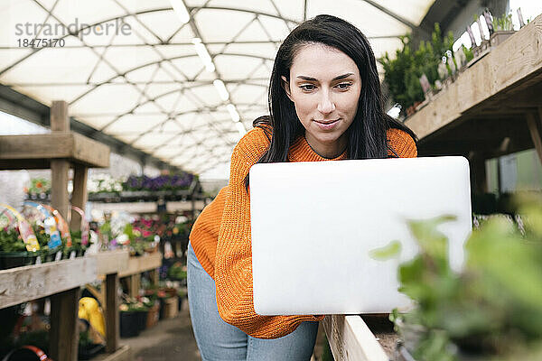 Frau arbeitet am Laptop im Gartencenter