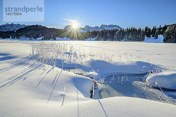 Deutschland  Bayern  Sonne geht über einem schneebedeckten See in den Bayerischen Alpen auf