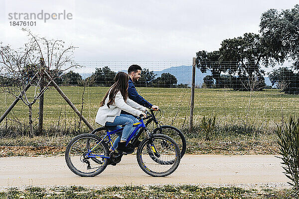 Paar fährt Fahrrad auf unbefestigter Straße