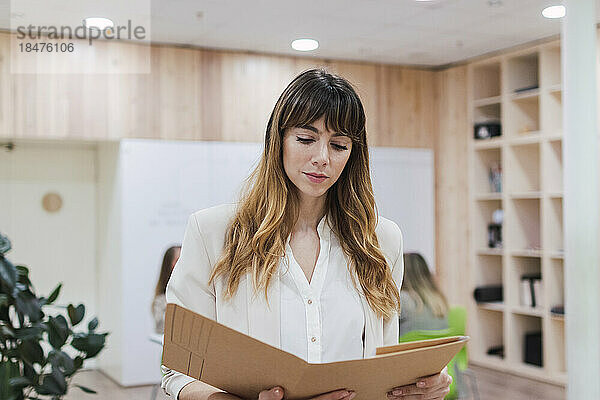 Businesswoman looking into folder in office