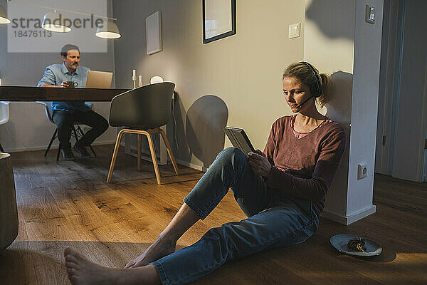 Freiberufler arbeitet zu Hause mit einem Tablet-PC auf dem Boden