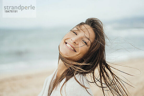 Glückliche Frau mit langen Haaren  die am Strand genießt