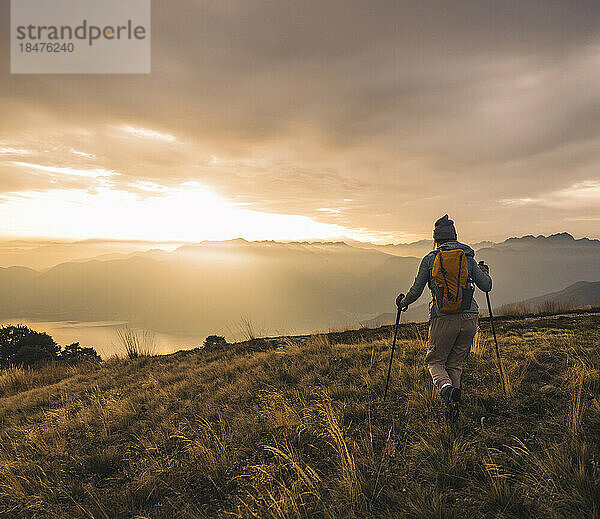 Reife Frau mit Wanderstöcken  die auf dem Berg spaziert