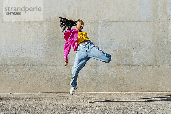 Junger Hip-Hop-Tänzer tanzt vor der Wand