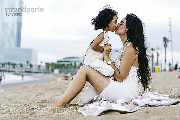 Junge küsst Mutter am Strand auf den Mund
