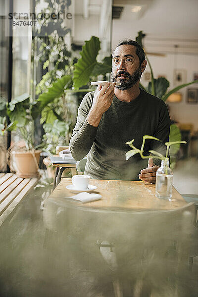 Reifer Mann spricht im Café über die Freisprecheinrichtung