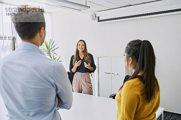 Manager gesturing in meeting with colleagues at workplace