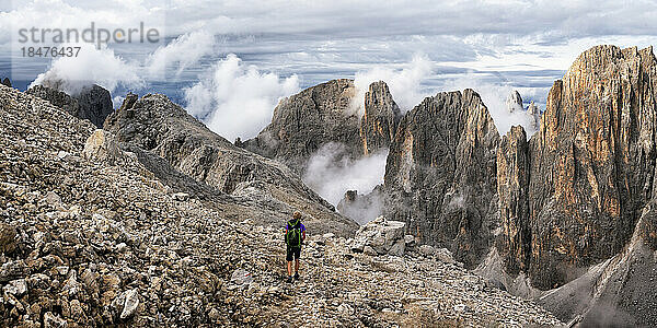 Ältere Frau wandert auf einem Berg unter bewölktem Himmel in Pala di San Martino  Dolomiten  Italien