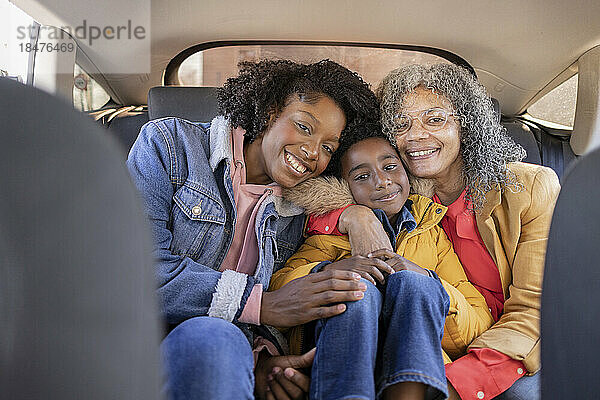 Lächelnde Familie mit mehreren Generationen  die zusammen im Auto sitzt