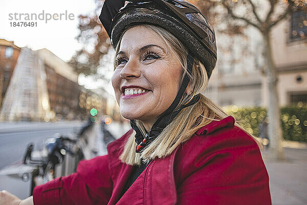 Fröhliche reife Frau mit Fahrradhelm