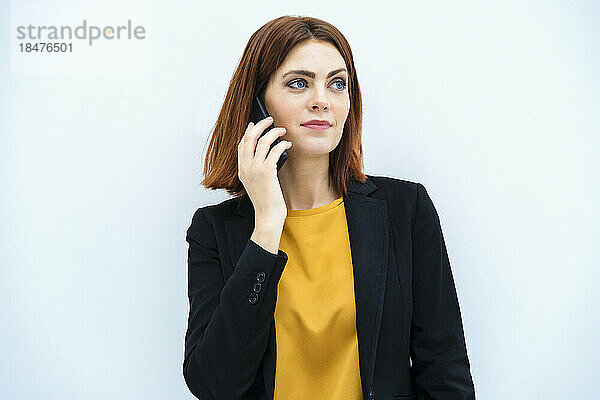 Geschäftsfrau am Telefon vor weißem Hintergrund
