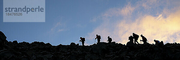 Silhouette-Freunde wandern auf dem Berg Ararat bei Sonnenuntergang