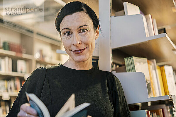 Frau mit Buch in der Bibliothek