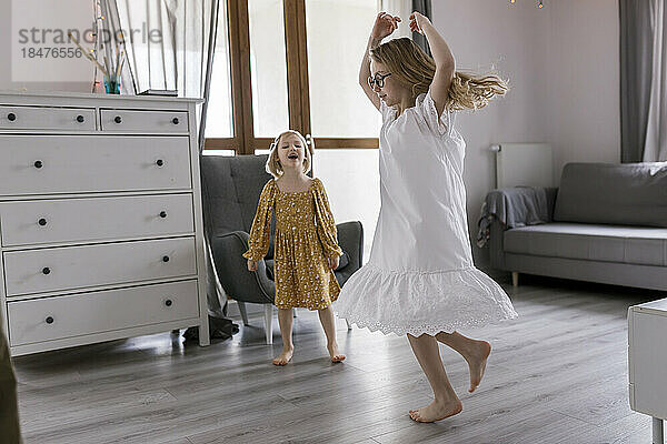 Sisters enjoying dance in living room at home