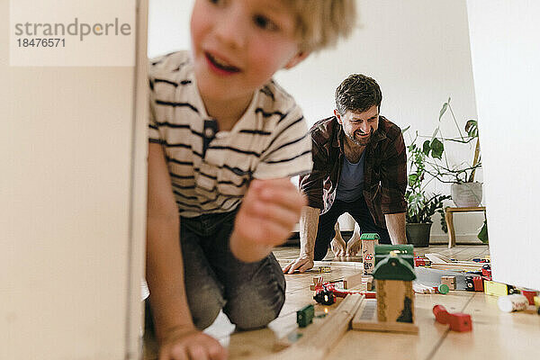 Father and son playing with toys at home